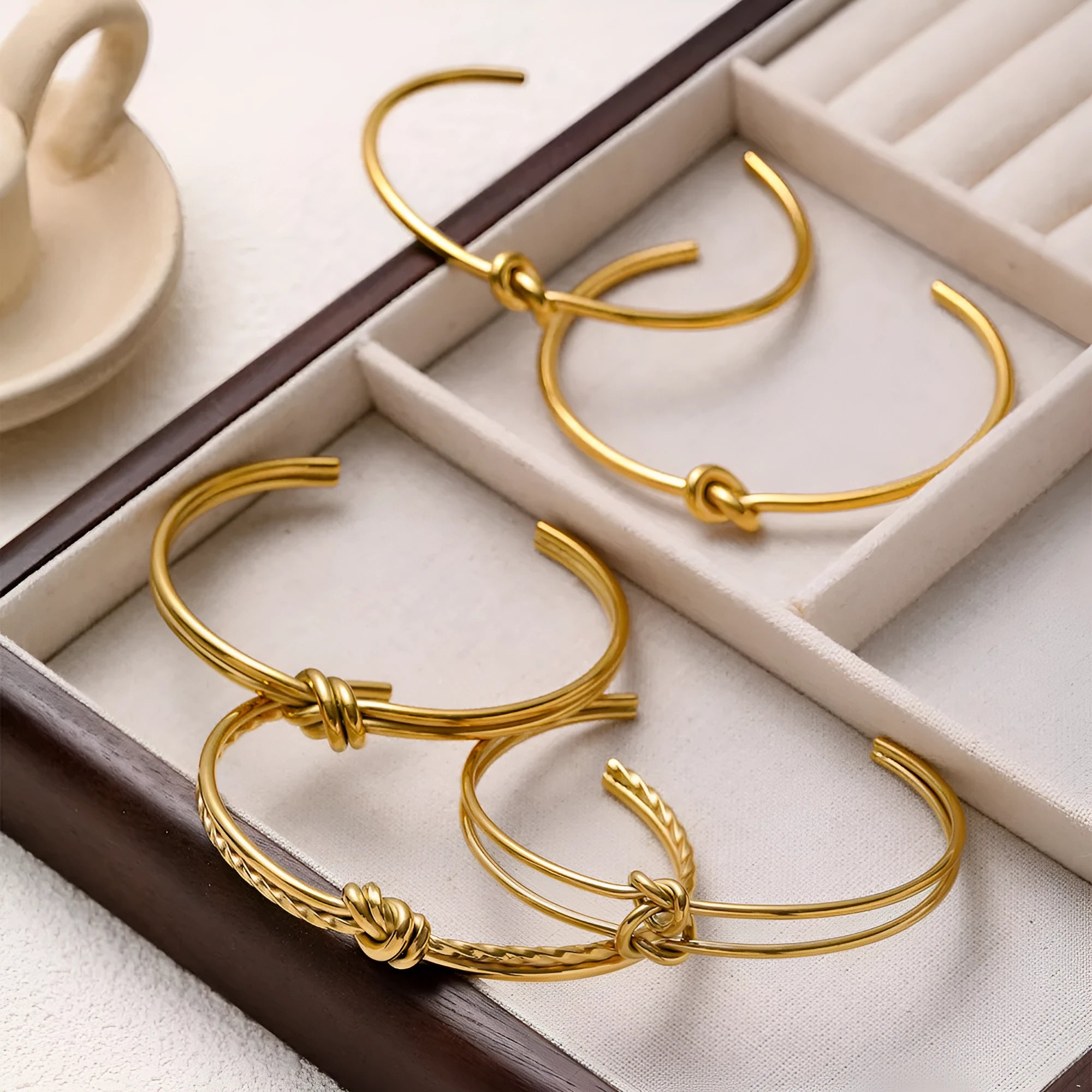 Women's adjustable knotted C-shaped open double-layer bracelet in gold or silver plated stainless steel.