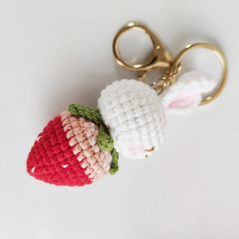 Hand-woven white doll wire pendant with cartoon rabbit and strawberry design on a key ring.