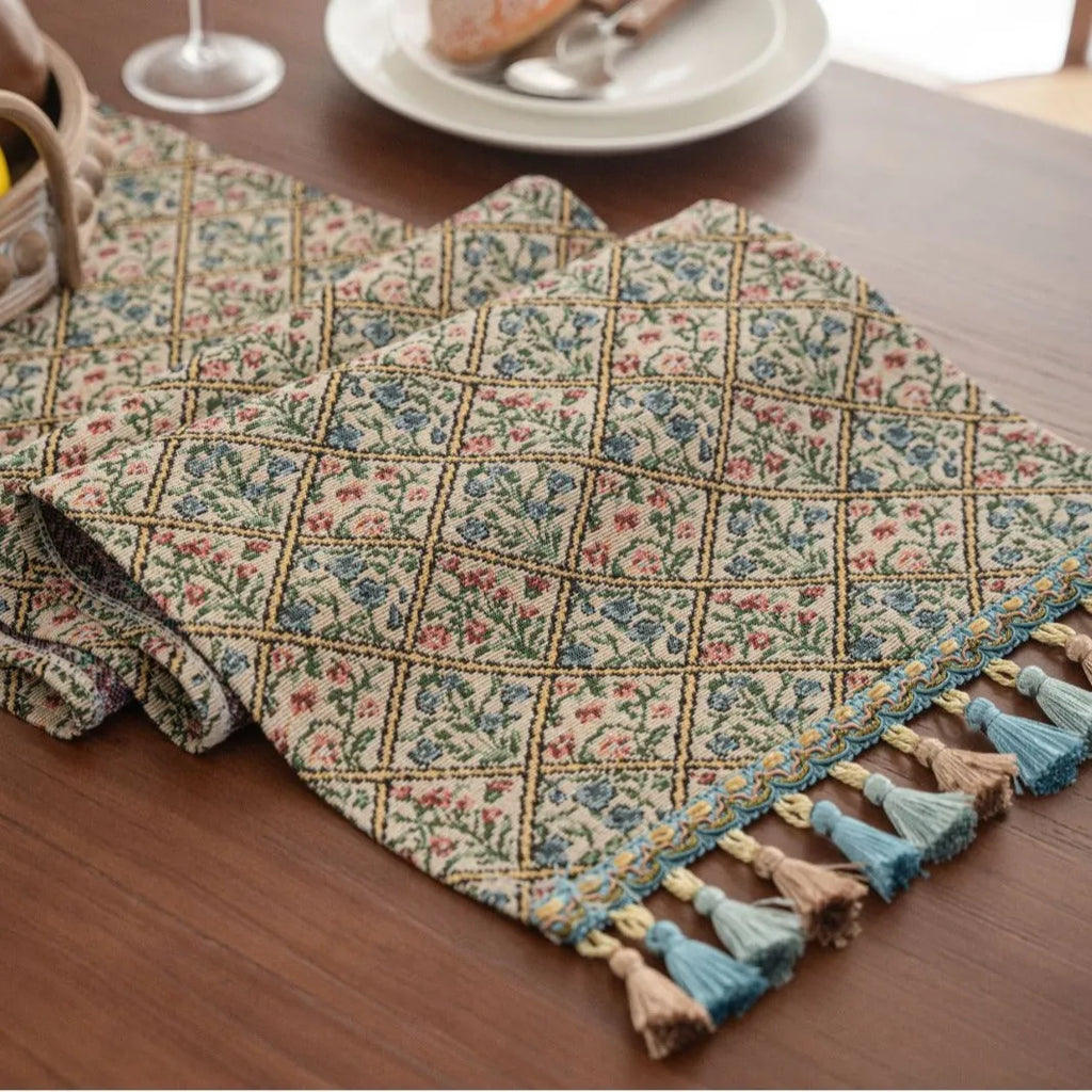 Dark blue striped Nordic jacquard bouquet table runner with tassel trim laid flat on a table.