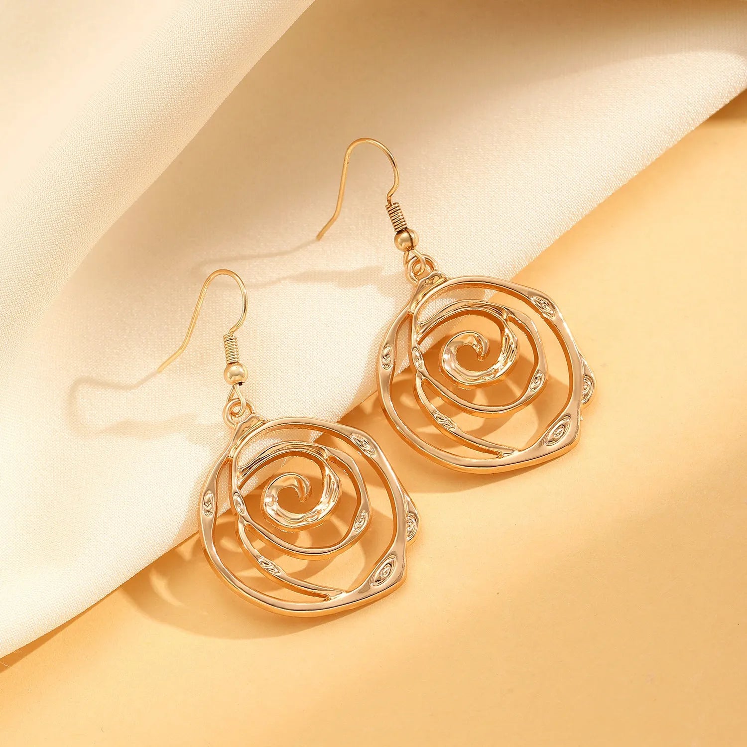 Women's spiral donut jewellery set showing bracelet, earrings, and adjustable necklace in gold tone
