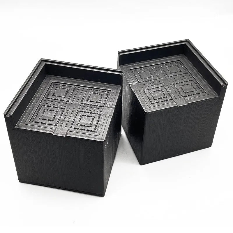 Four black plastic furniture riser feet for bed and sofa height adjustment