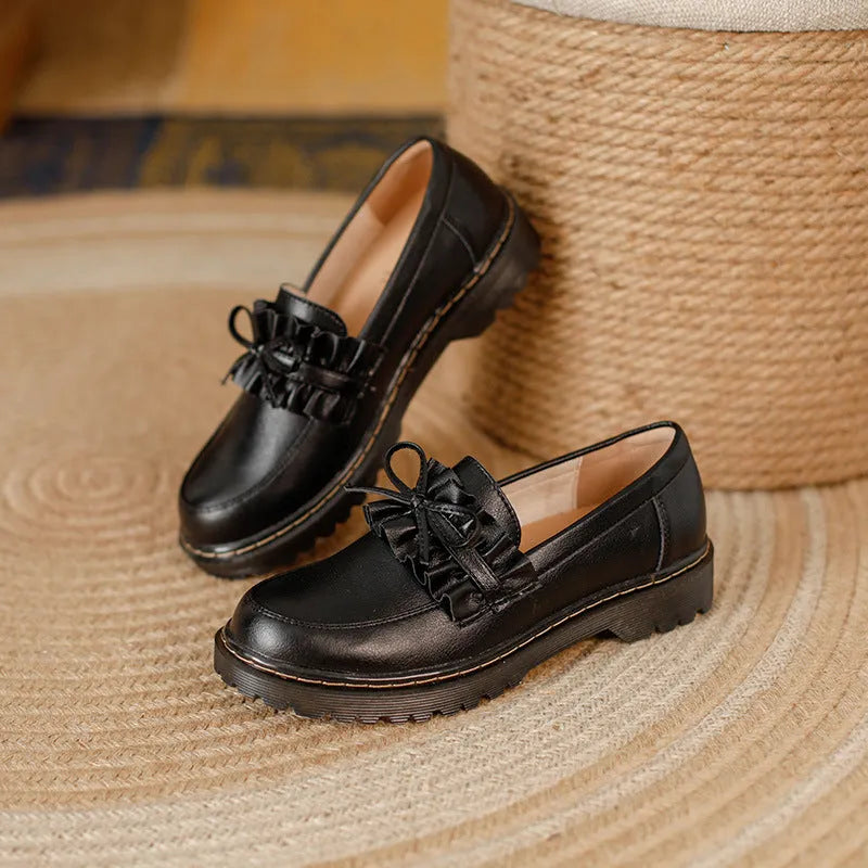 Black and brown women's round toe leather shoes with a chunky flat heel and low upper.