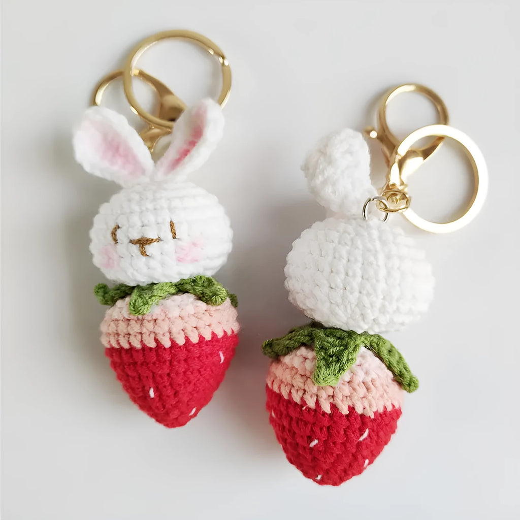 Hand-woven white doll wire pendant with cartoon rabbit and strawberry design on a key ring.