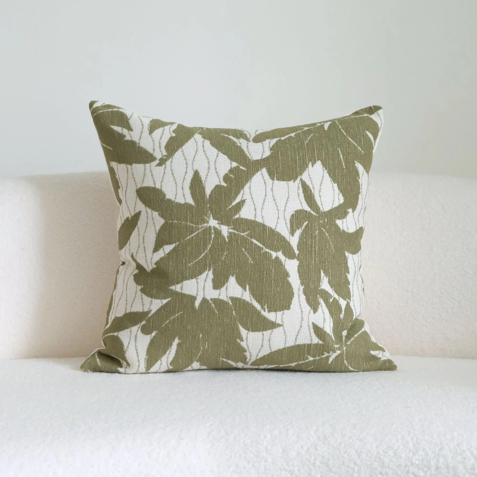 Green cotton and linen hotel sample pillow with botanical pattern and tassel trim