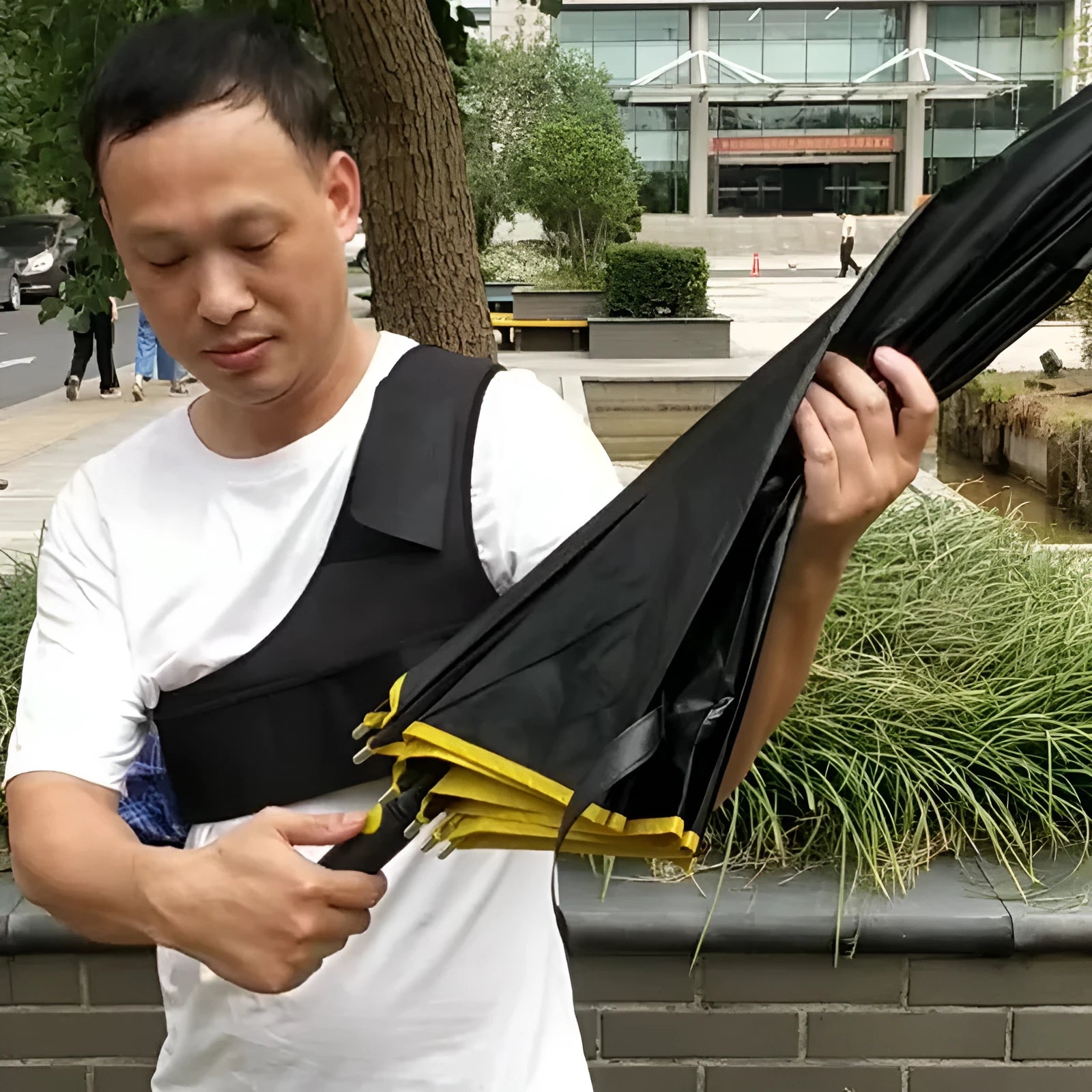 Black portable umbrella holder with a shoulder strap designed for manual 10-bone umbrellas.