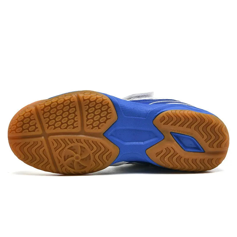 White and blue breathable PVC badminton shoes with a ribbed sole on a court surface.