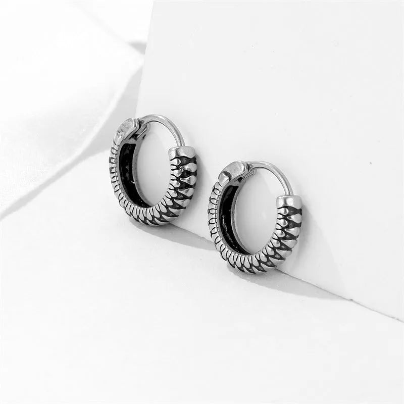 Silver geometric earrings with retro twist design and striped detailing on circular stainless steel form