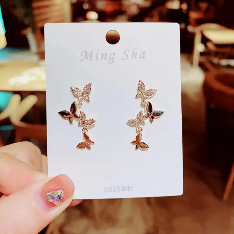 Gold-coloured copper earrings with butterfly design in ear drop style for women