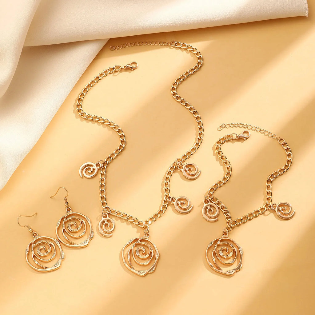 Women's spiral donut jewellery set showing bracelet, earrings, and adjustable necklace in gold tone