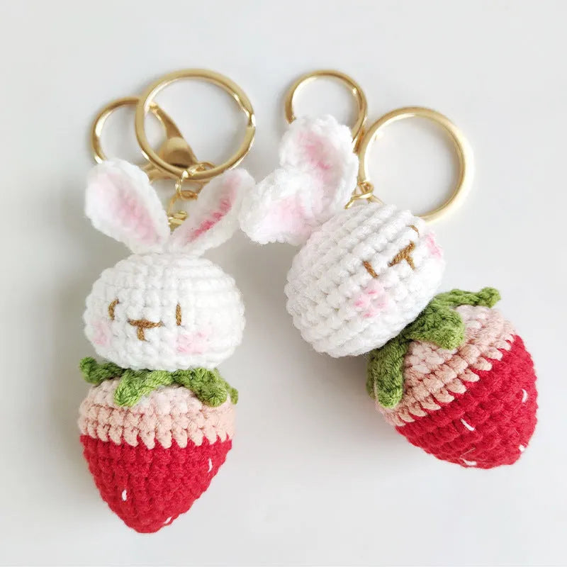 Hand-woven white doll wire pendant with cartoon rabbit and strawberry design on a key ring.