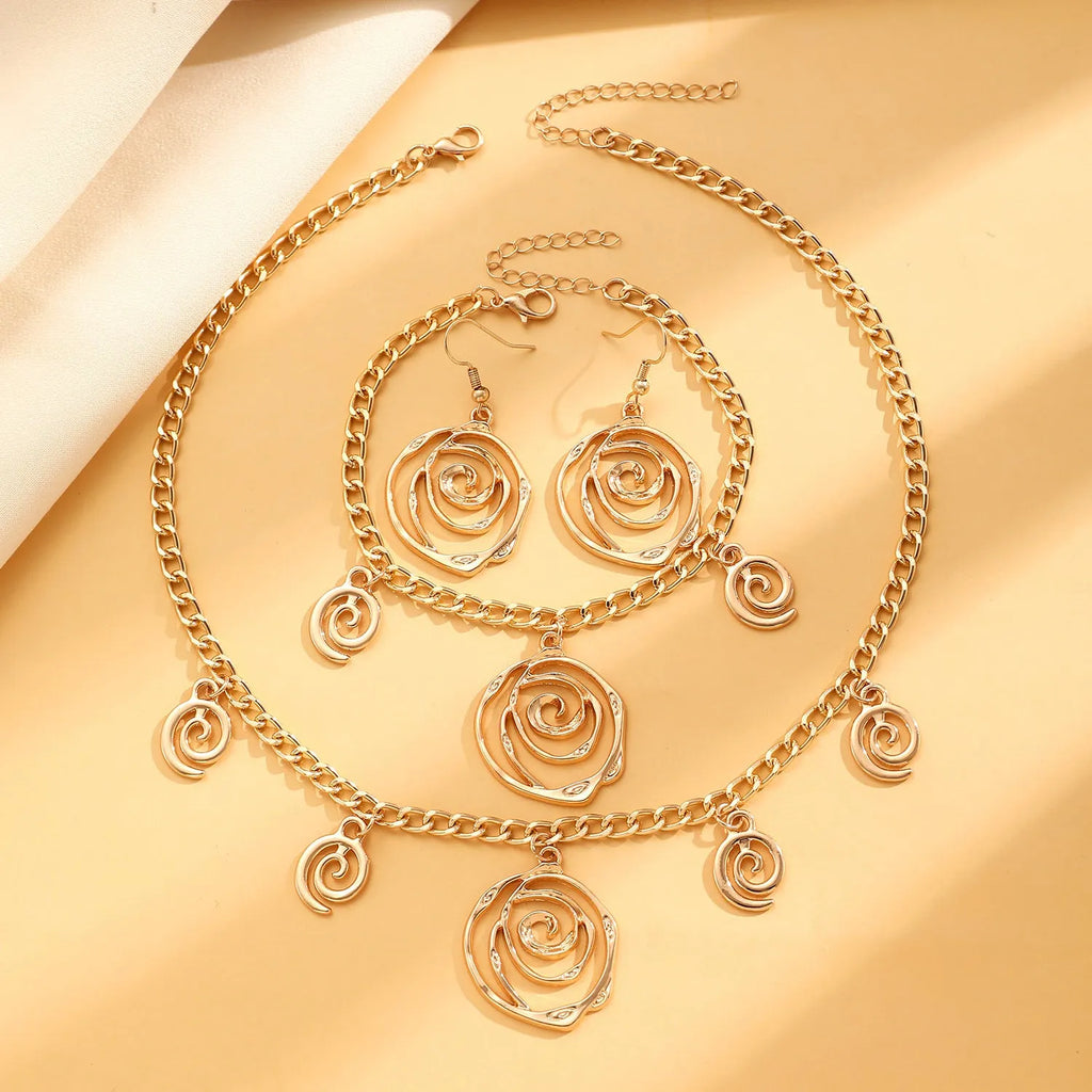 Women's spiral donut jewellery set showing bracelet, earrings, and adjustable necklace in gold tone