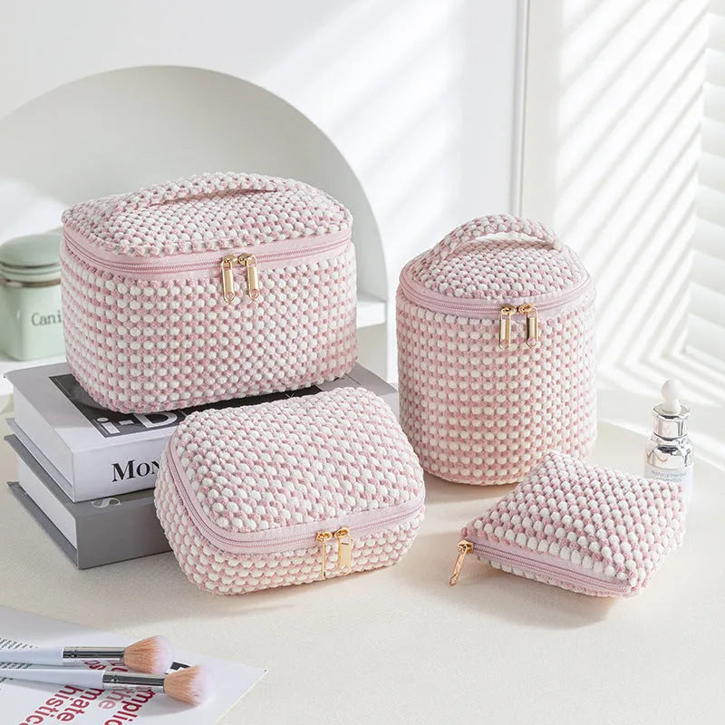 Four cube-shaped polyester makeup bags in coordinated set for cosmetics organisation