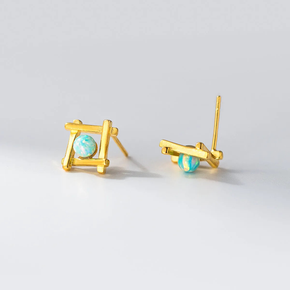 Geometric cross shaped stud earrings in sterling silver with angular design and gold or silver finish