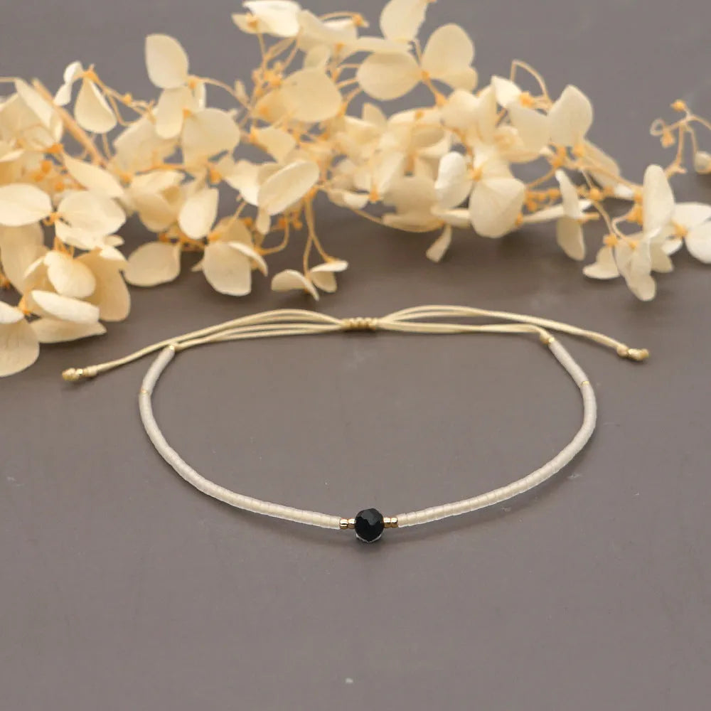 Women's handmade bohemian bracelet with colourful geometric glass and glaze beads on a wrist.
