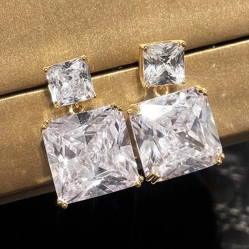 A pair of geometric square copper earrings for women, shown in white gold and gold colour finishes.