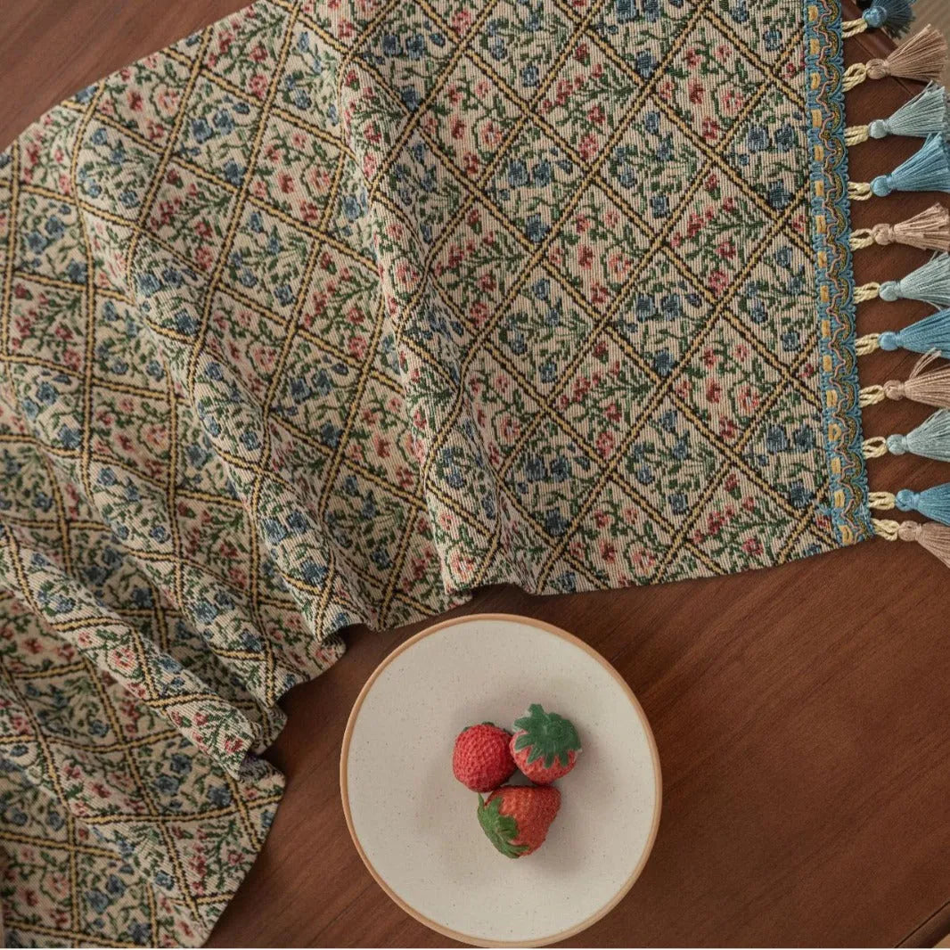 Dark blue striped Nordic jacquard bouquet table runner with tassel trim laid flat on a table.