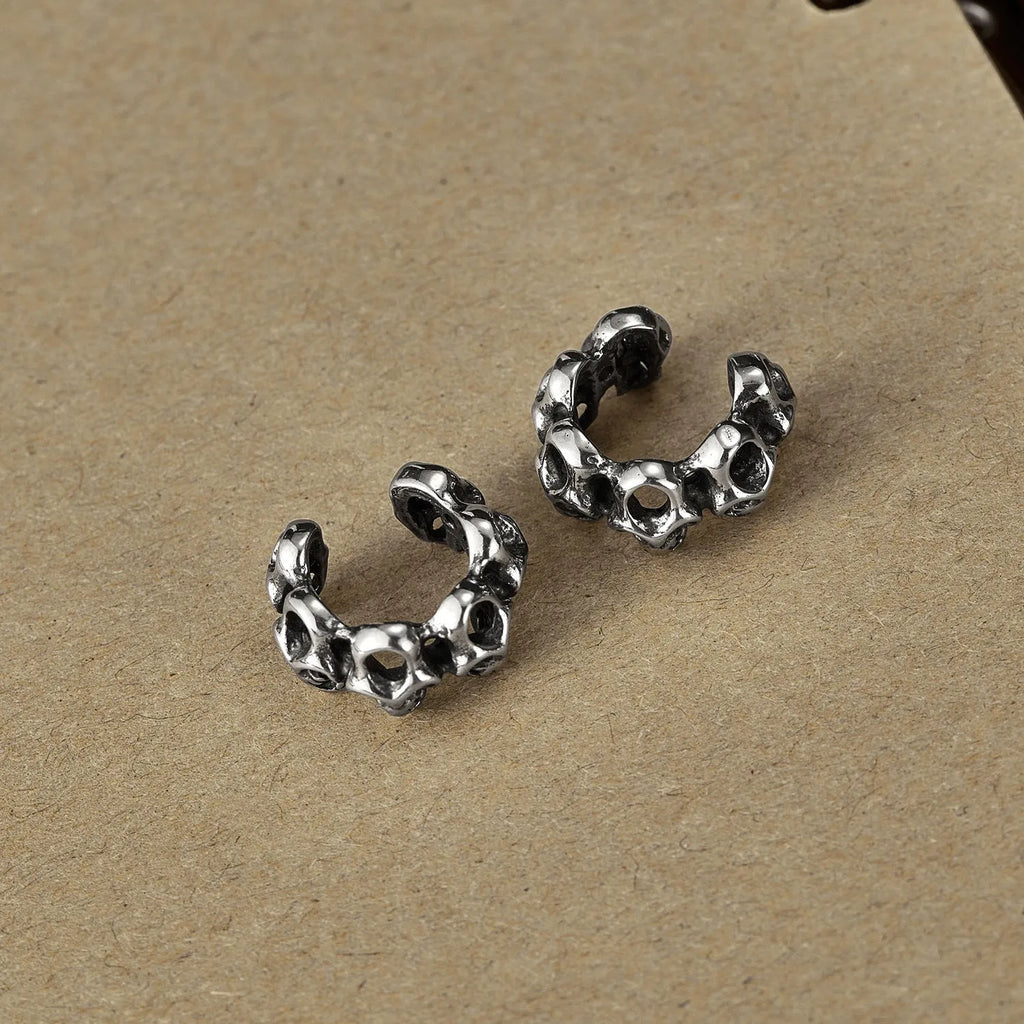 Stainless steel skull earrings with clip-on fastening and hollow geometric design