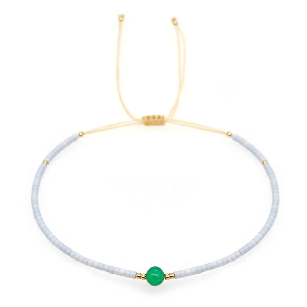 Women's handmade bohemian bracelet with colourful geometric glass and glaze beads on a wrist.
