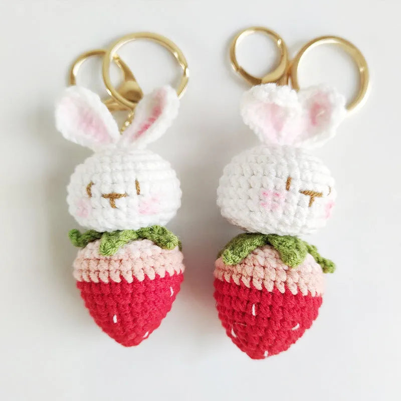 Hand-woven white doll wire pendant with cartoon rabbit and strawberry design on a key ring.