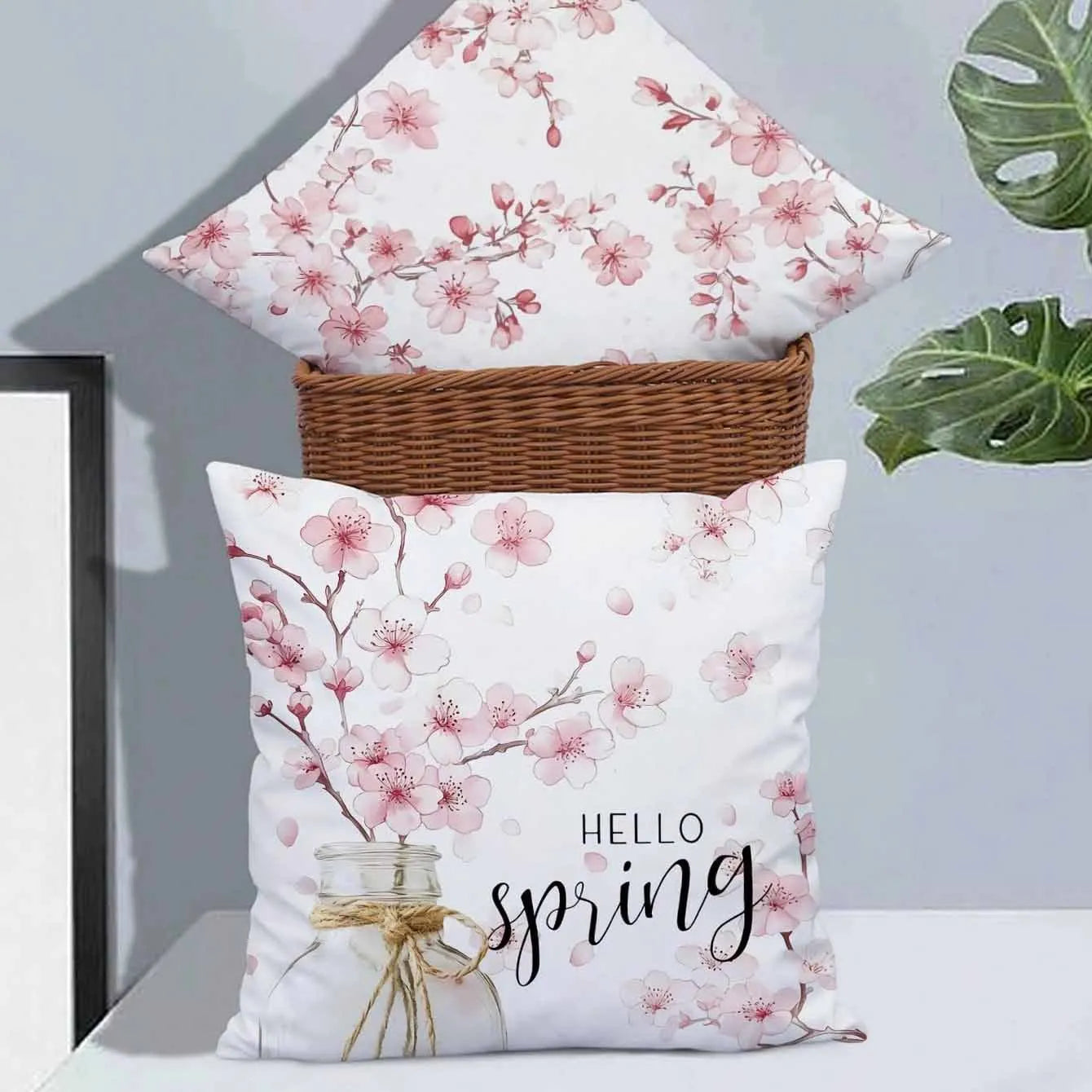 Short velvet square cushion cover with cherry blossom letter print, shown in one of four colour options.