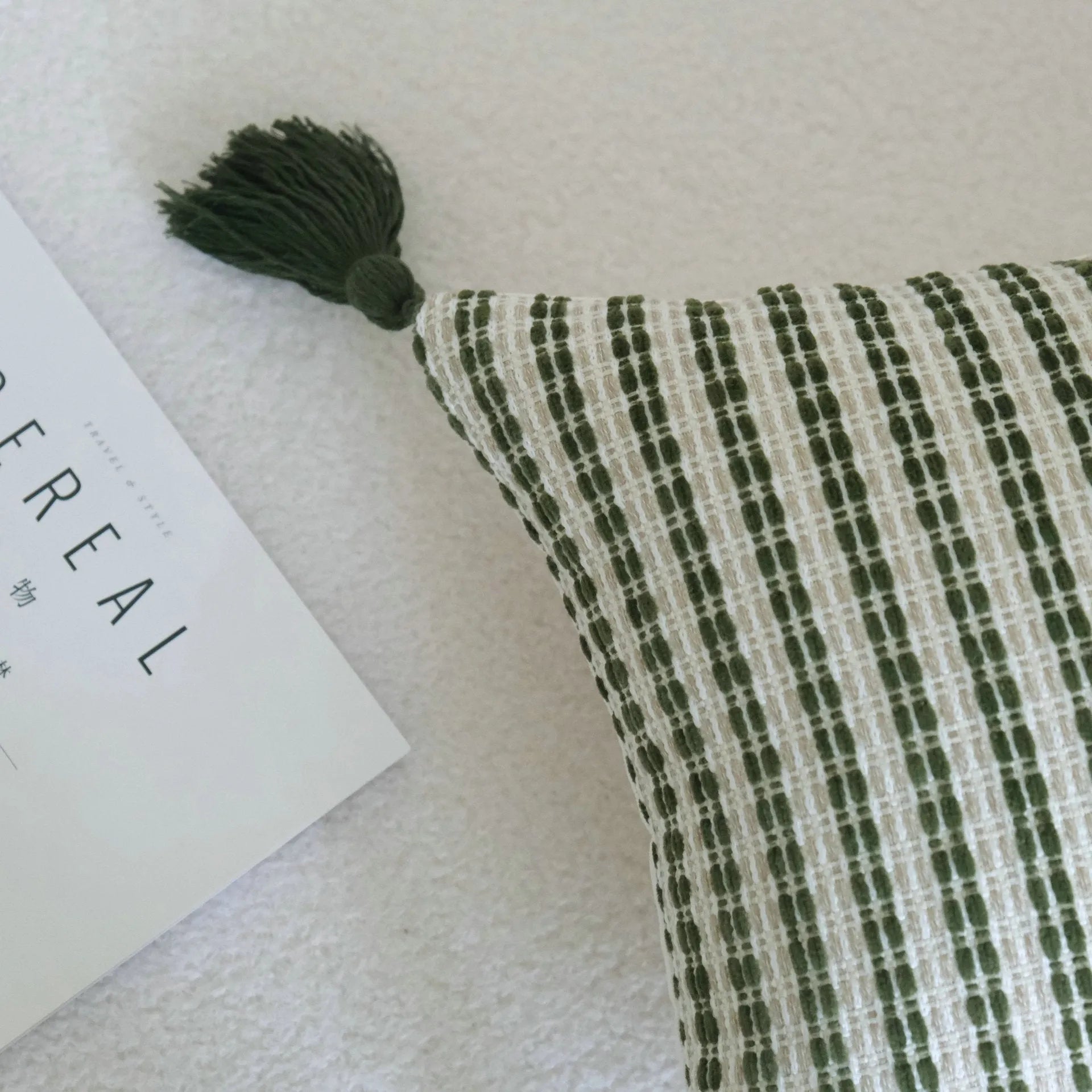 Green cotton and linen hotel sample pillow with botanical pattern and tassel trim