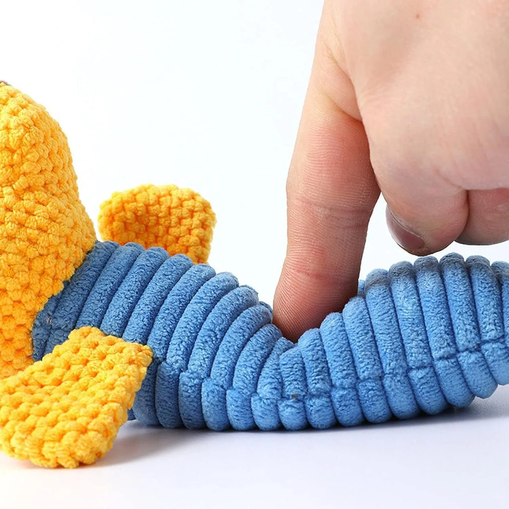 Soft plush dog chew toy in animal shape with squeaker, shown with size scale.