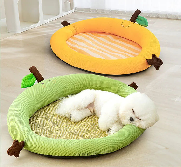 Green pet cooling mat with a raised fruit-shaped backrest, shown with a dog resting on it.