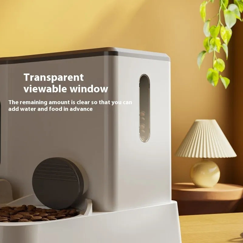 Grey automatic cat feeder and water dispenser station with integrated double bowls on a wooden floor.