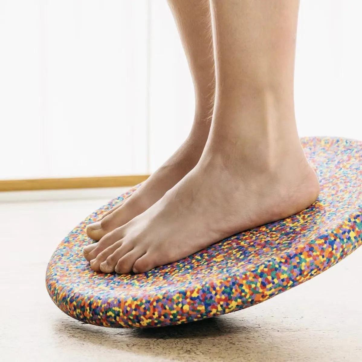 A plastic balance board for children, shown in mixed wood colour and solid black options.