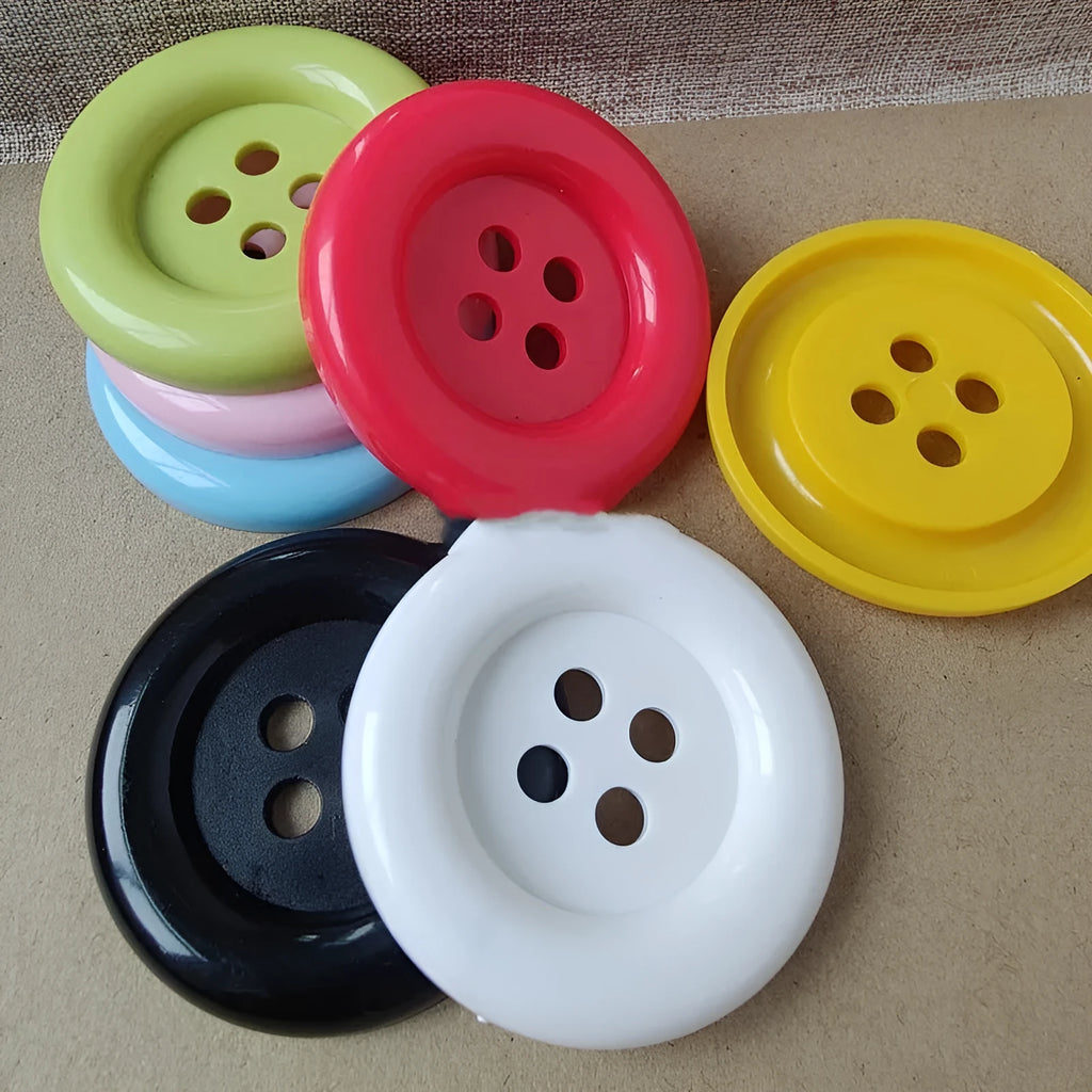Oversized round plastic button with four holes in various colours and sizes from 38mm to 70mm.