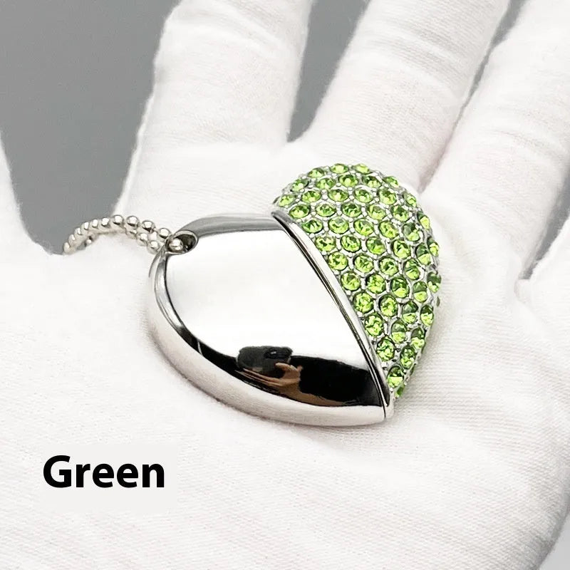 A heart-shaped silver USB flash drive with a brick pattern, shown next to a laptop.
