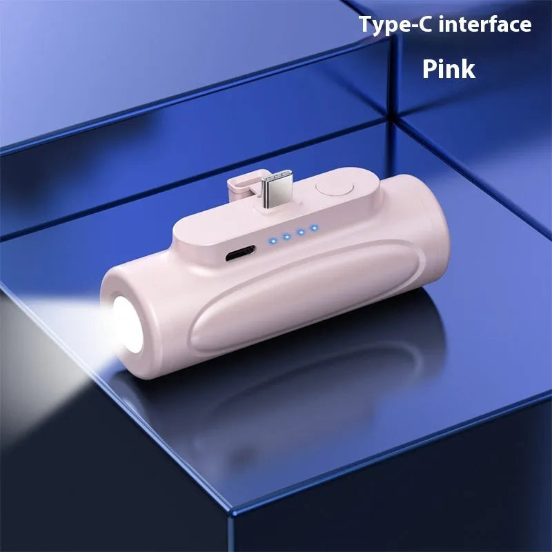 Black and pink creative power bank with integrated LED flashlight glare, showing Type-C and Apple port options.