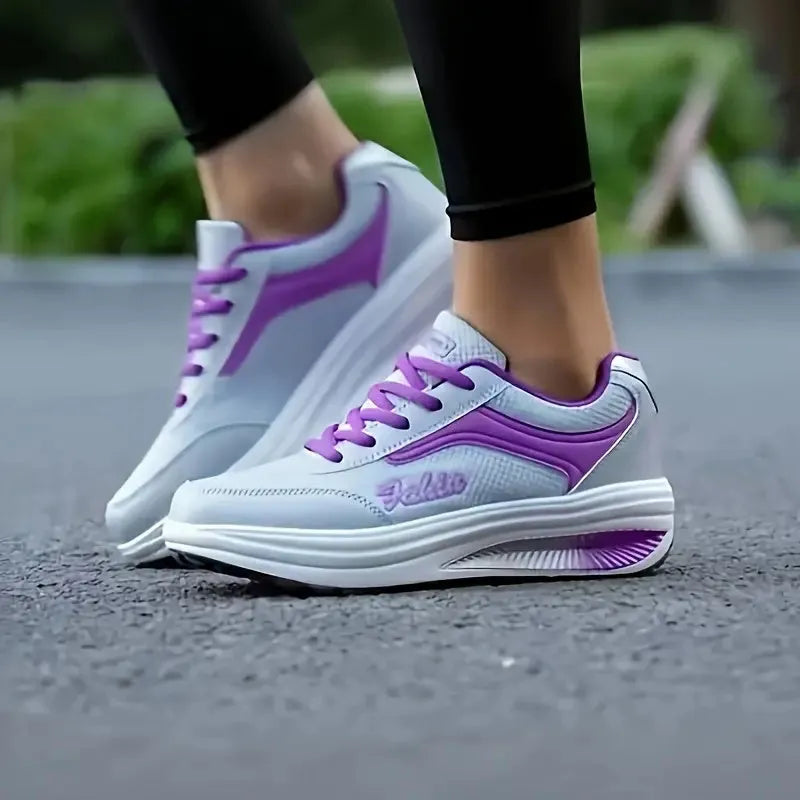 Women's grey pink heelless sports travel shoes with a mid heel on a neutral background.