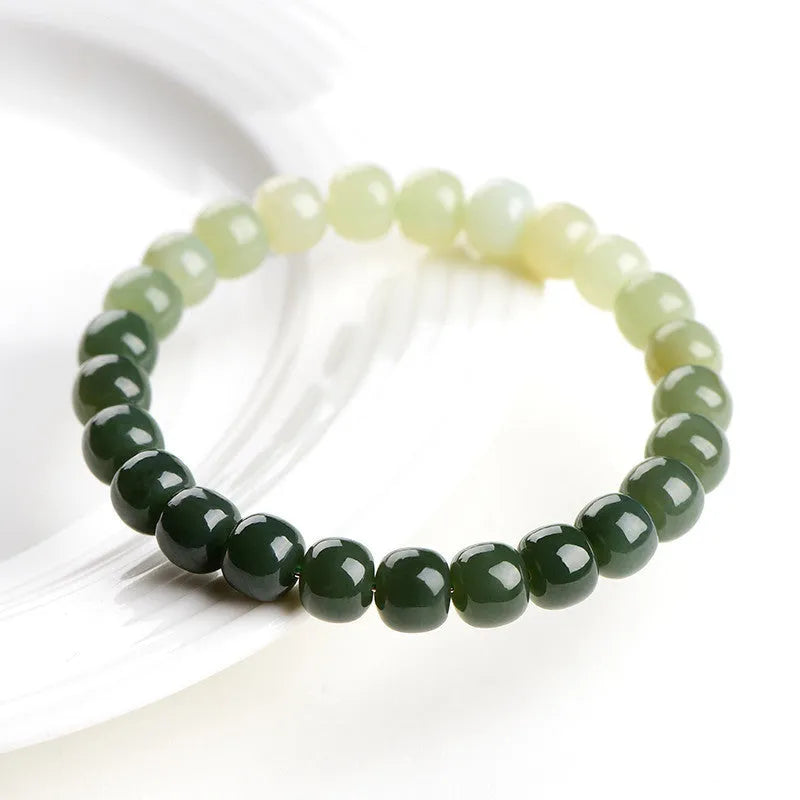 Natural Hetian Jade bracelet showing water gradient colour on wrist, with polished beads.