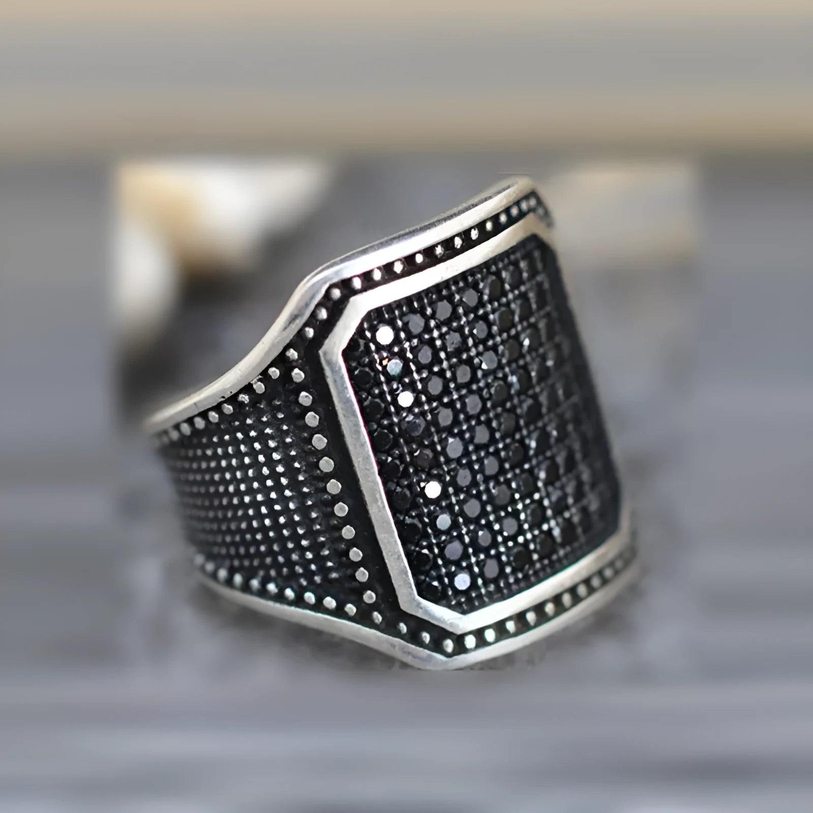 Black alloy ring with copper inlay and a central zircon stone, shown in size 10.