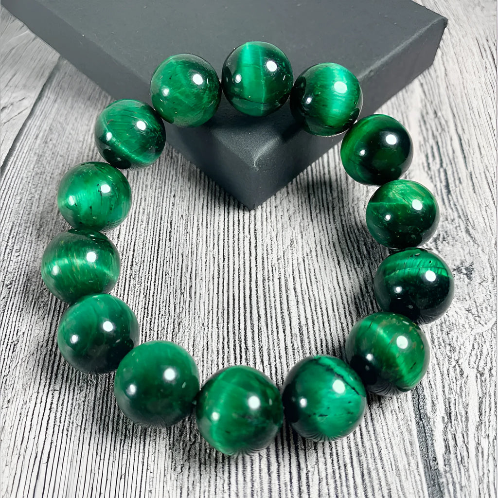 Green tiger eye stone bracelet with geometric beads on a wrist.