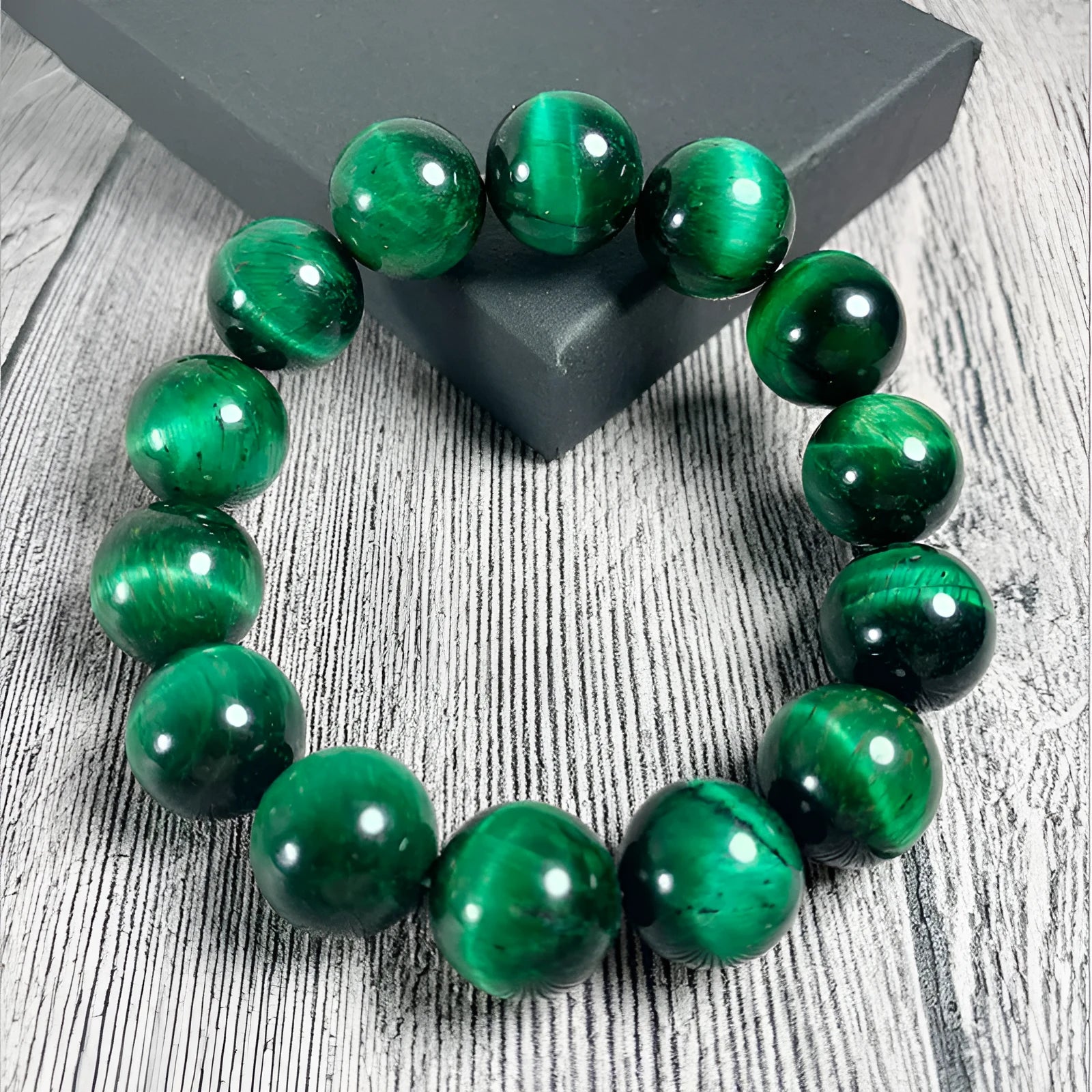 Green tiger eye stone bracelet with geometric beads on a wrist.