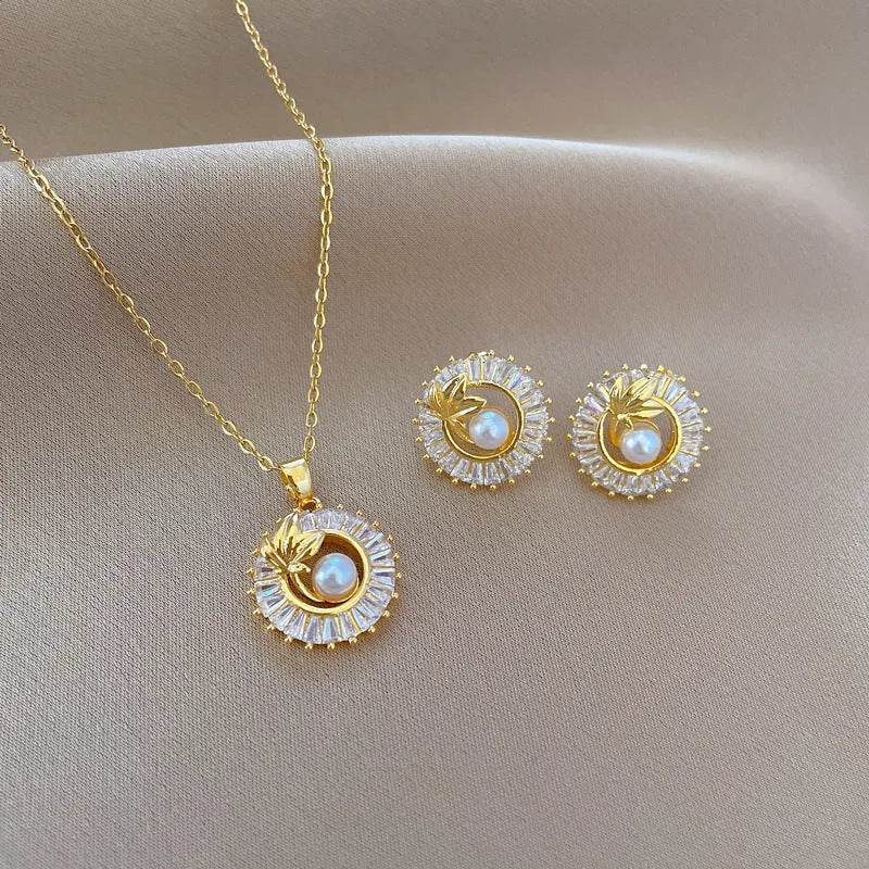 A titanium steel jewellery set with a square diamond and leaf design necklace and matching stud earrings.