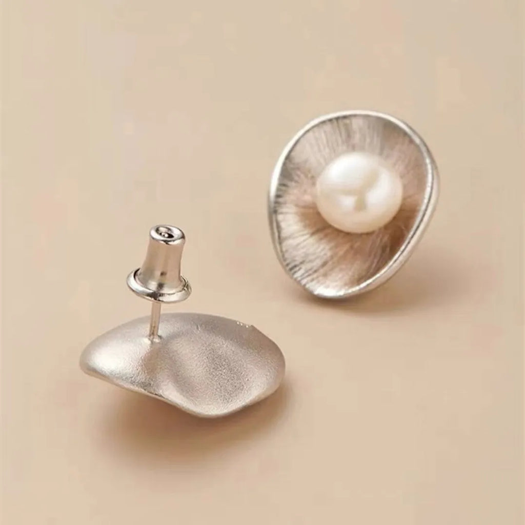 A pair of gold-coloured geometric sterling silver stud earrings featuring a single pearl.
