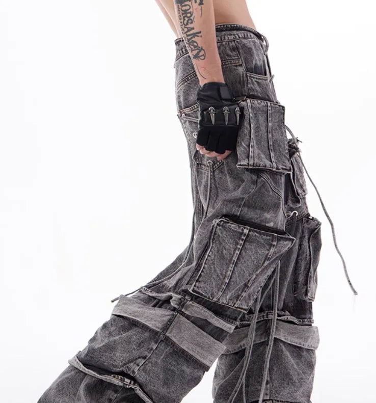 Grey distressed denim overalls with rope stitching detail on a hanger.