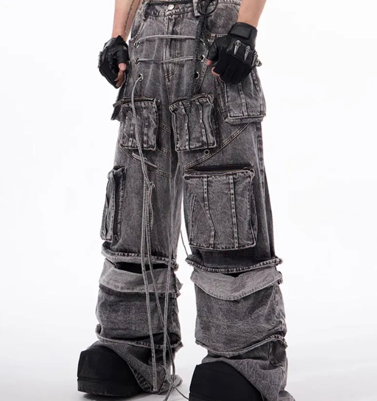 Grey distressed denim overalls with rope stitching detail on a hanger.