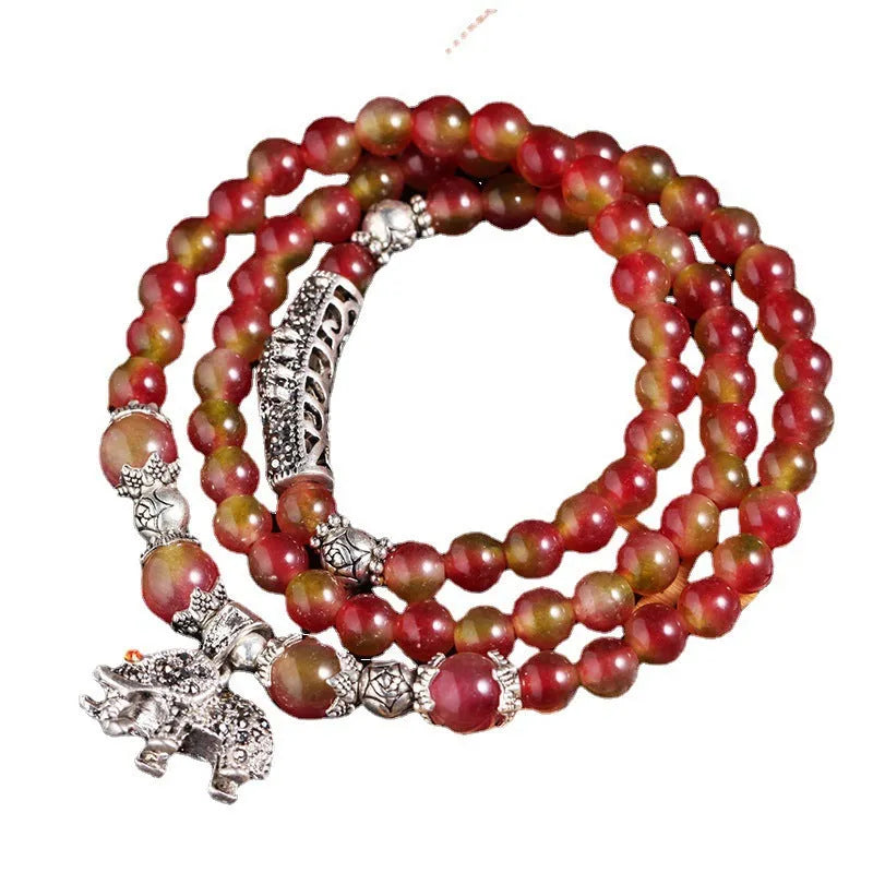 Handmade bracelet with a watermelon crystal elephant bead on a Chinese knot cord.