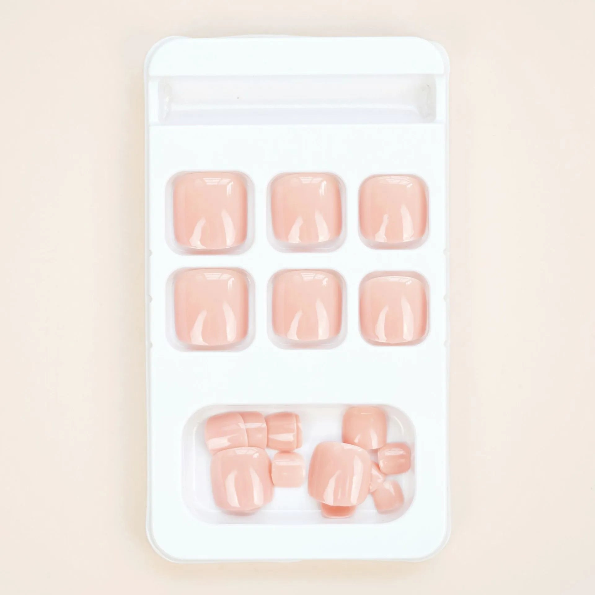Plastic toenail stickers in skin colour J-52 with a tube of glue for application.