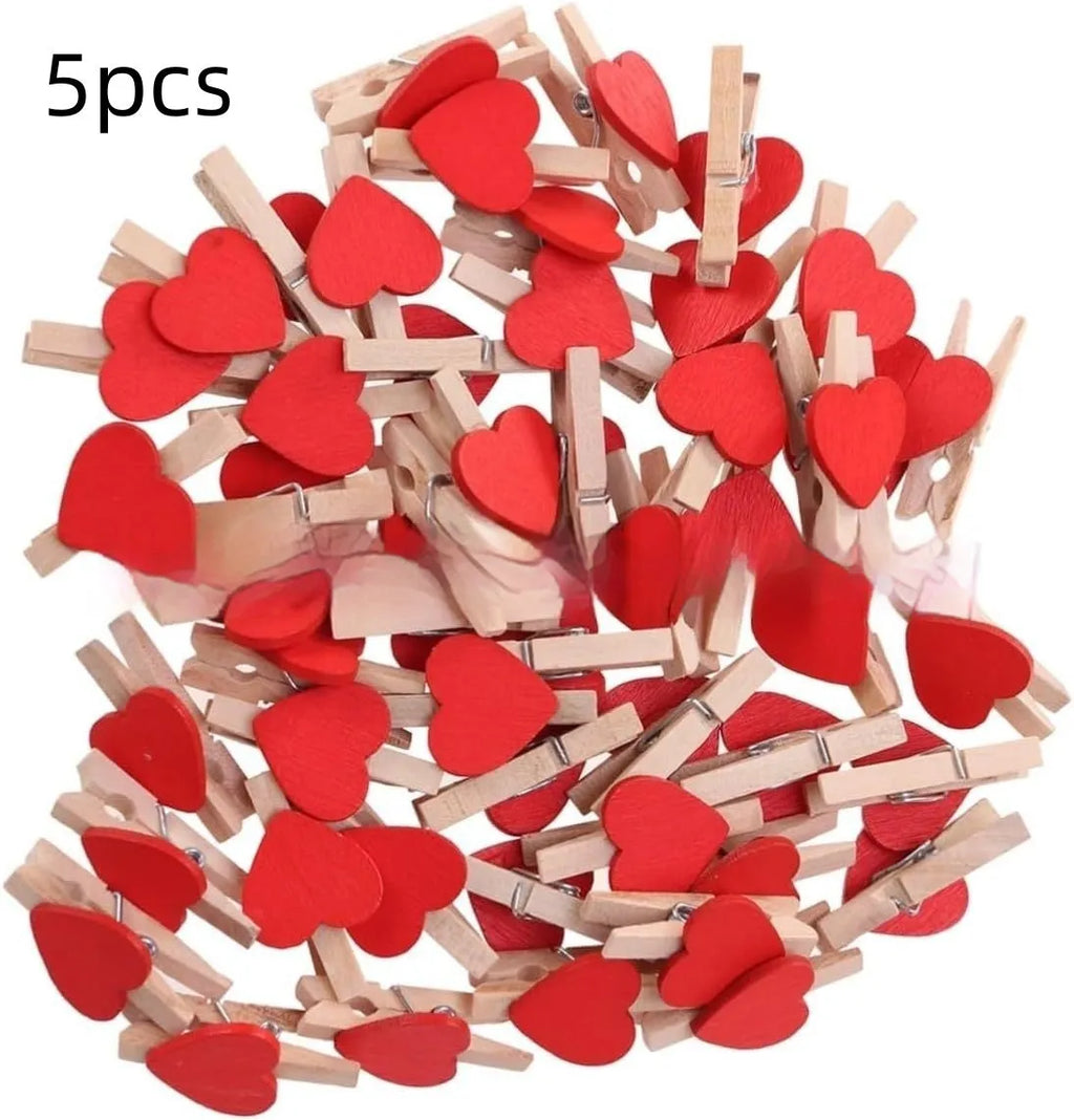 Five small handmade solid wood heart-shaped clips in assorted colours on a white surface.