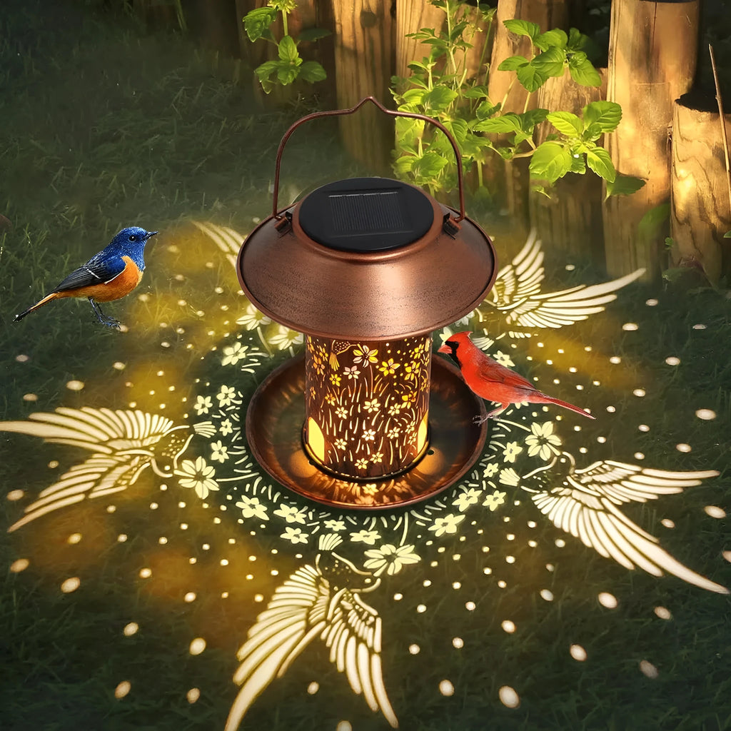 Iron solar bird feeder with hummingbird pattern and integrated LED light for outdoor garden use.