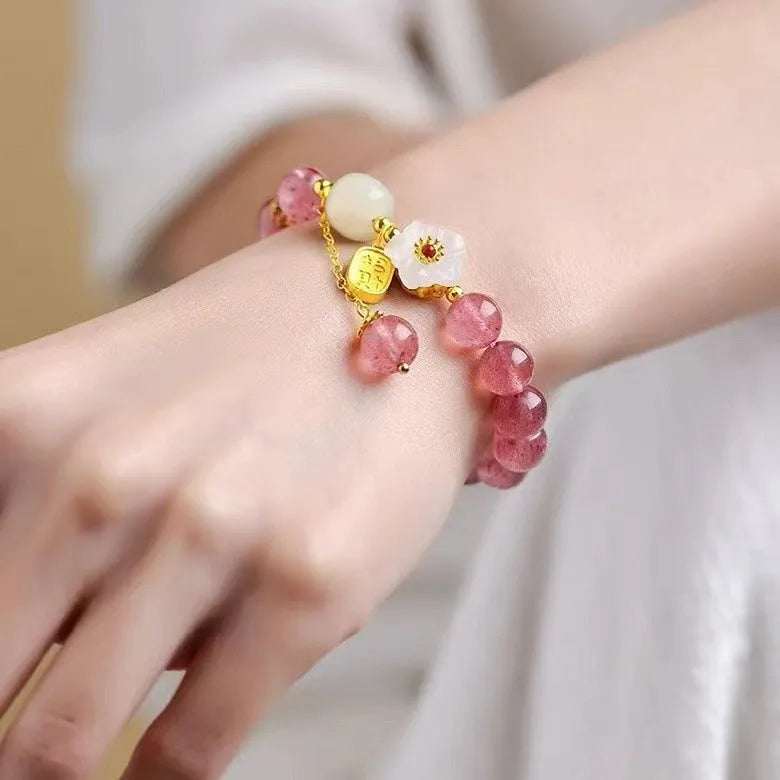 Adjustable strawberry quartz bracelet with Hetian jade peach blossom charm on wrist