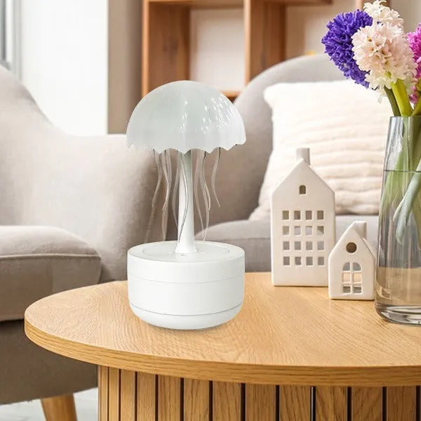 White jellyfish-shaped humidifier and essential oil diffuser with colourful LED night light on a desktop.