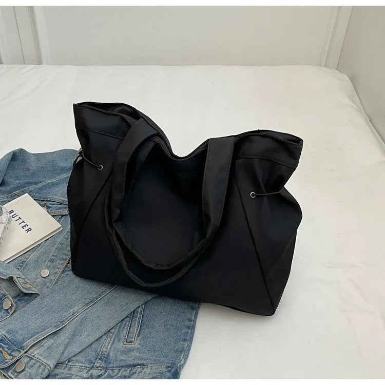 Soft oxford cloth folding commuter tote bag in street style, shown in black, grey, brown, and purple colours.