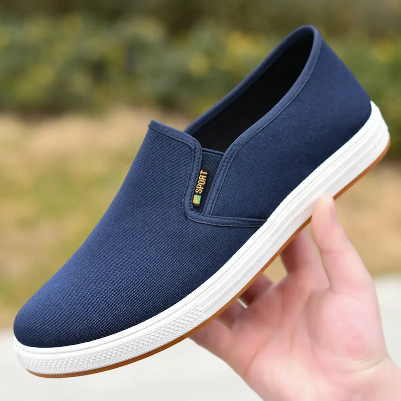 Men's black low-top slip-on canvas shoes with a round toe and composite sole on a white background.
