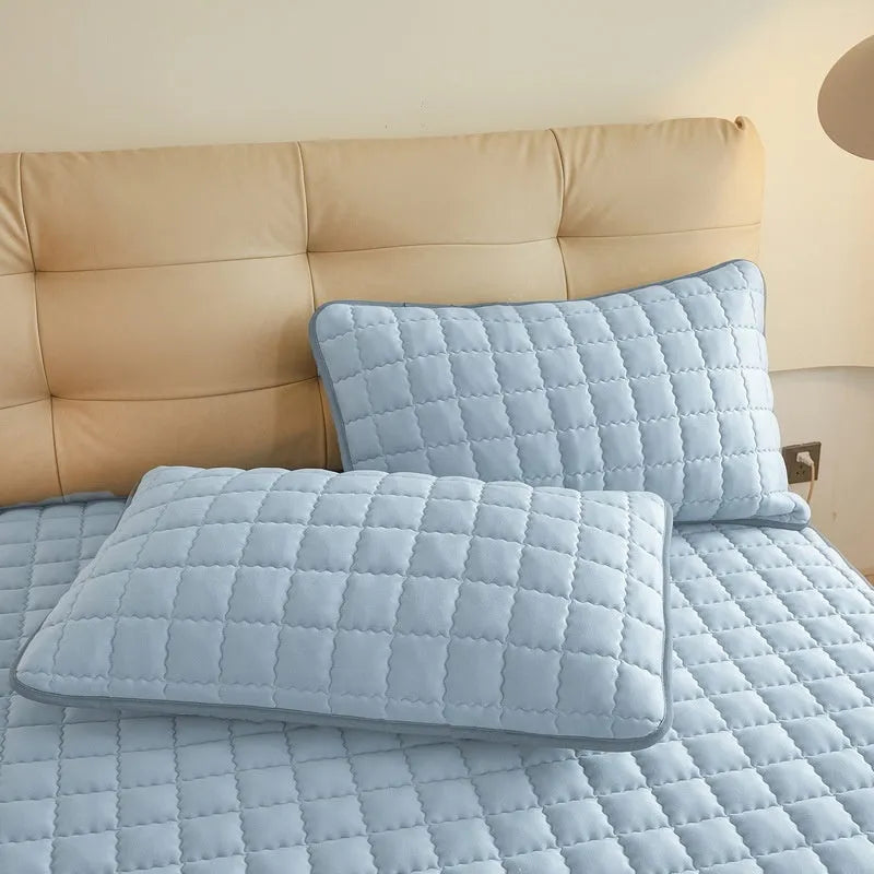 Blue washed cotton waterproof fitted sheet with elasticated corners shown on mattress